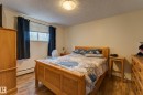 Bedroom featuring wood-finish flooring, a window with blinds, and neutral wall tones