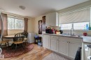 Kitchen area featuring light wood-finish flooring, white cabinetry, and a double basin sink