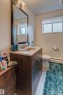 Bathroom vanity with a granite countertop, undermount sink, and wood-finish cabinetry