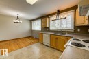Kitchen and dining area featuring light wood cabinetry, a double basin sink, and a range with a built-in oven