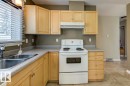 Functional kitchen with light wood-finish cabinetry and a double basin stainless steel sink
