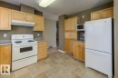 Kitchen featuring wood-finish cabinetry, light-toned countertops, and tile flooring