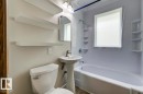 Bathroom featuring a white bathtub, white pedestal sink, and white toilet