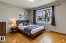Hardwood flooring throughout, large window with ample natural light, neutral painted walls, and a ceiling-mounted light fixture