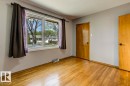 Bright room featuring hardwood flooring, light gray wall paint, and two wood-panel doors