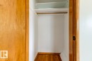 Closet interior featuring a hanging rod, upper shelf, and wood-finish flooring