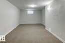 Spacious room featuring neutral carpeting, light gray wall paint, and white trim