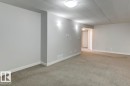 Spacious room featuring neutral carpeting, light gray wall paint, and white trim