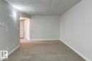 Spacious room featuring light gray walls, white trim, and light gray carpet flooring