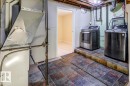 Basement utility area featuring a furnace, exposed ductwork, and plumbing