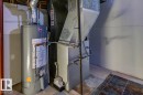 Utility area featuring a water heater, furnace, and exposed ductwork