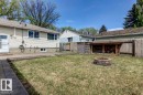 Spacious backyard featuring a stone-clad fire pit, wood privacy fencing, and a built-in wood storage structure