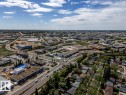 Aerial perspective of a mixed-use district featuring commercial buildings, residential properties, and paved roadways