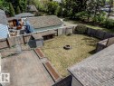 Expansive rear yard featuring a paved patio, grassy area, and a built-in fire pit
