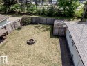 Spacious backyard featuring a stone-ringed fire pit, wood fencing, and a paver patio