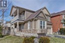 View of side of property with a balcony, a garage, driveway, stone siding, and roof with shingles View of side of property with a balcony, a garage, driveway, stone siding, and roof with shingles