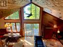 With vaulted cedar finished ceilings & expansive waterside windows.