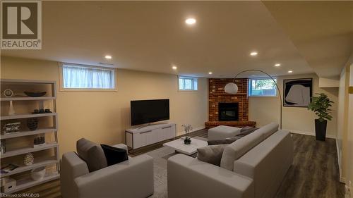 Living room featuring an Electric brick fireplace - Virtually Staged