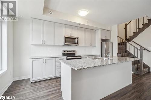 Kitchen featuring sink, white cabinets, and appliances with stainless steel finishes