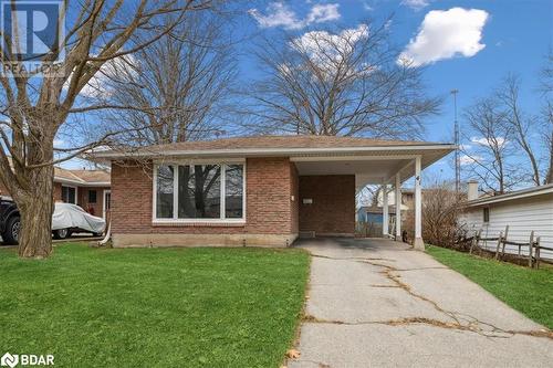 View of front facade with a front lawn and a carport