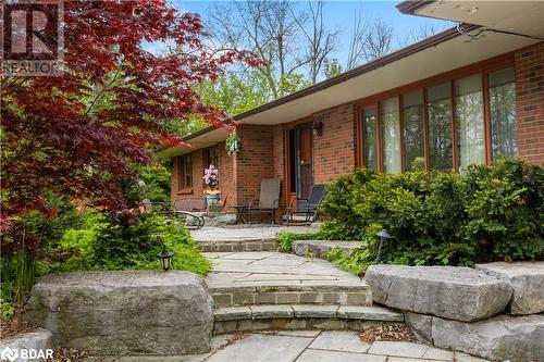 View of exterior entry featuring brick siding and a porch