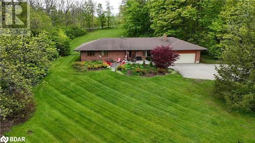 View of front facade with driveway, brick siding, a garage, and a front yard