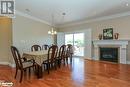 Dining area featuring light hardwood / wood-style floors, a tile fireplace, an inviting chandelier, and crown molding