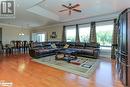 Living room featuring a wealth of natural light, a raised ceiling, and light hardwood / wood-style flooring