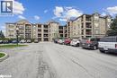 View of apartment building / complex with uncovered parking