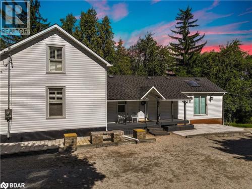 Back of house featuring roof with shingles, a deck, and a patio area