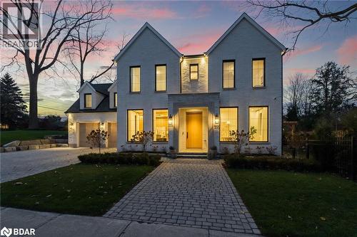 View of front of house featuring decorative driveway, a front lawn, brick siding, and a garage