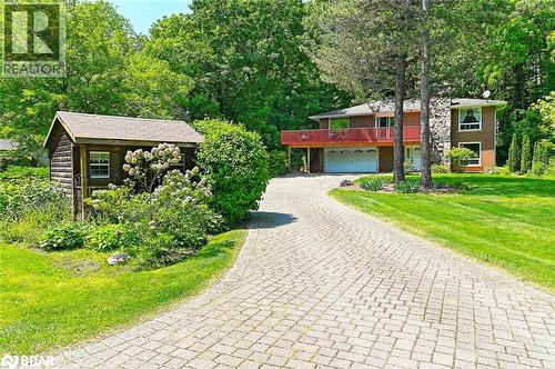 View of front of property featuring decorative driveway, an attached garage, a front yard, and brick siding