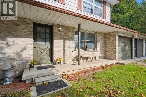 Entrance to property with a porch and brick siding