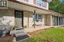 Entrance to property with a porch and brick siding