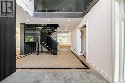 Open-Riser Staircase Featuring Smoked Glass Panels