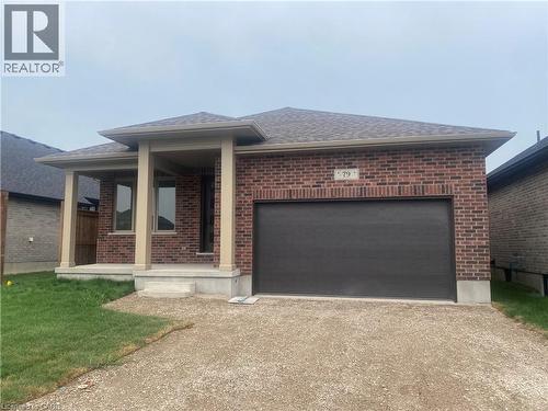 Ranch-style home with driveway, brick siding, a garage, and roof with shingles