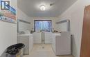 Shared laundry room featuring separate washer and dryer and light tile patterned floors