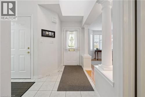 Entryway with light tile patterned floors and baseboards