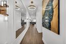Hall featuring dark wood-style flooring, recessed lighting, and a chandelier