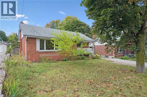Ranch-style house with a front lawn, brick siding, a chimney, and a shingled roof