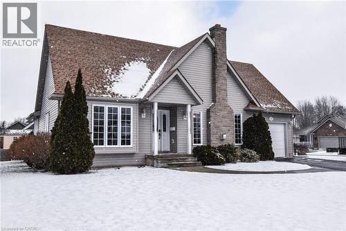 View of front of house with a chimney and a garage