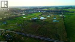 Expansive green fields featuring multiple ponds and distant wooded areas