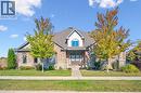Craftsman-style home featuring a front lawn, brick siding, and roof with shingles