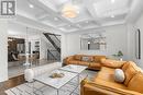 Great room with coffered ceiling and pot lighting.