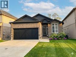 Craftsman inspired home with an attached garage, brick siding, board and batten siding, concrete driveway, and a front lawn