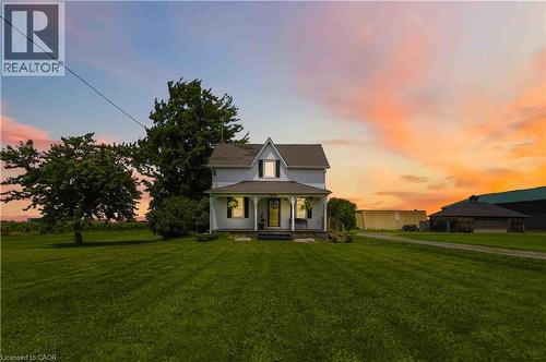 Two-story traditional farmhouse featuring a gabled roofline and a covered front porch