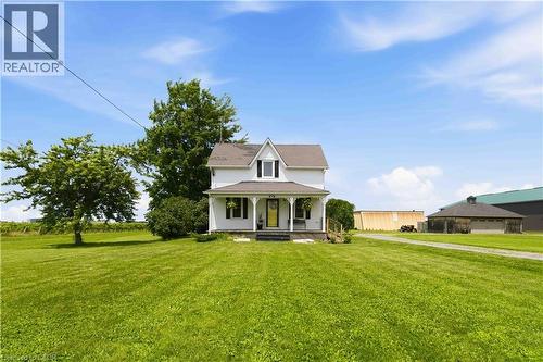 Two-story home featuring a covered front porch, white siding, and a gabled roofline