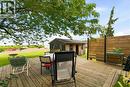 Expansive wood deck with a privacy fence, mature trees, and a separate storage shed