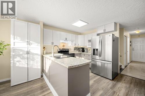 Kitchen featuring new countertops, stainless steel refrigerator with ice dispenser, updated cabinets and oversized pantry with eat-up peninsula