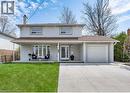 View of front of house with a chimney, stucco siding, an attached garage, a porch, and driveway
